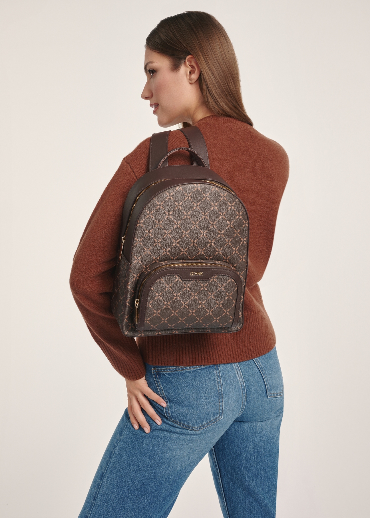 Women's backpack with monogram TOREC-0980A-89(Z25), front view of the product on a model, half of the silhouette visible.