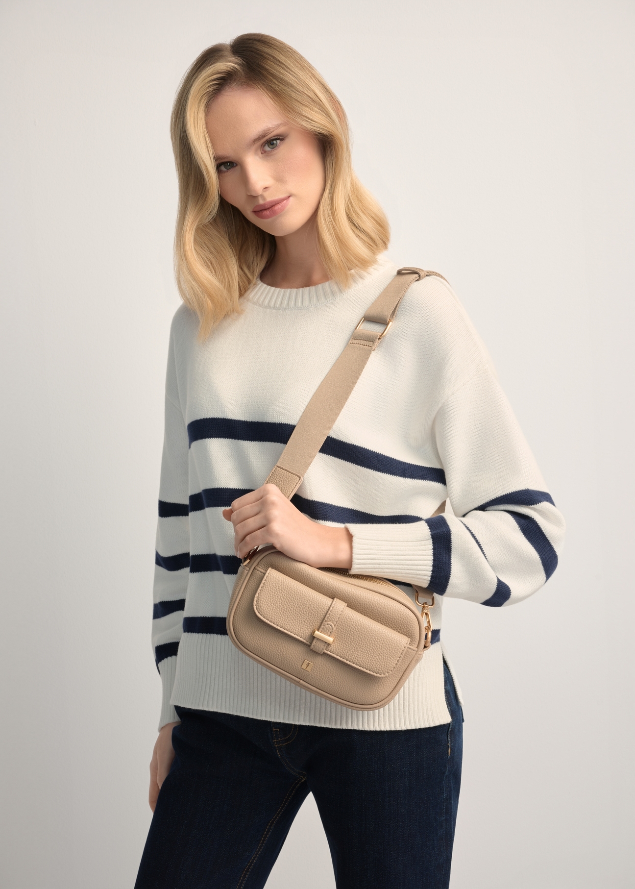 Small beige women's handbag TOREC-1174-1B(W26), product view on model's shoulder. Half of silhouette visible.