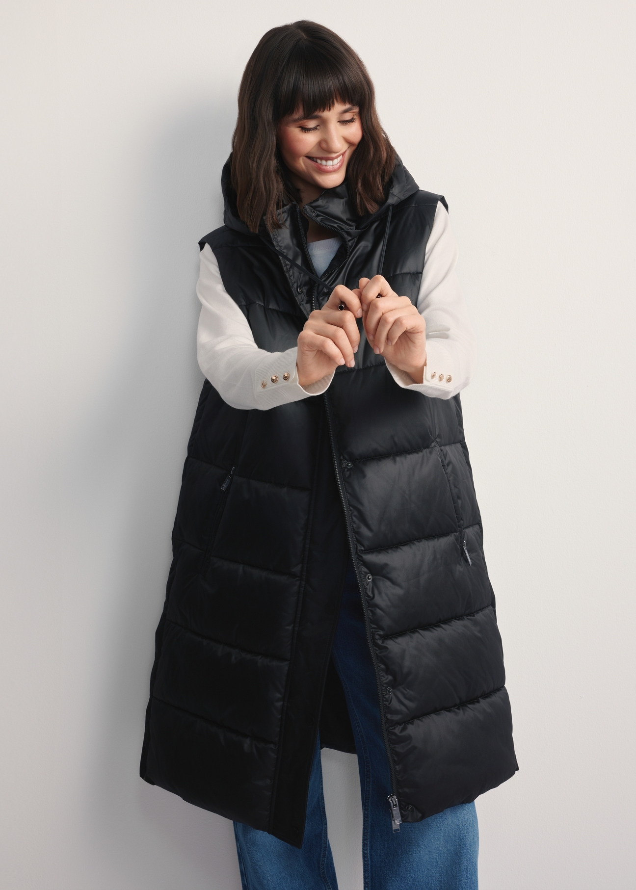 Black insulated women's vest KAMDT-0028-99(Z25), front view of the product on a model, half of the silhouette visible.