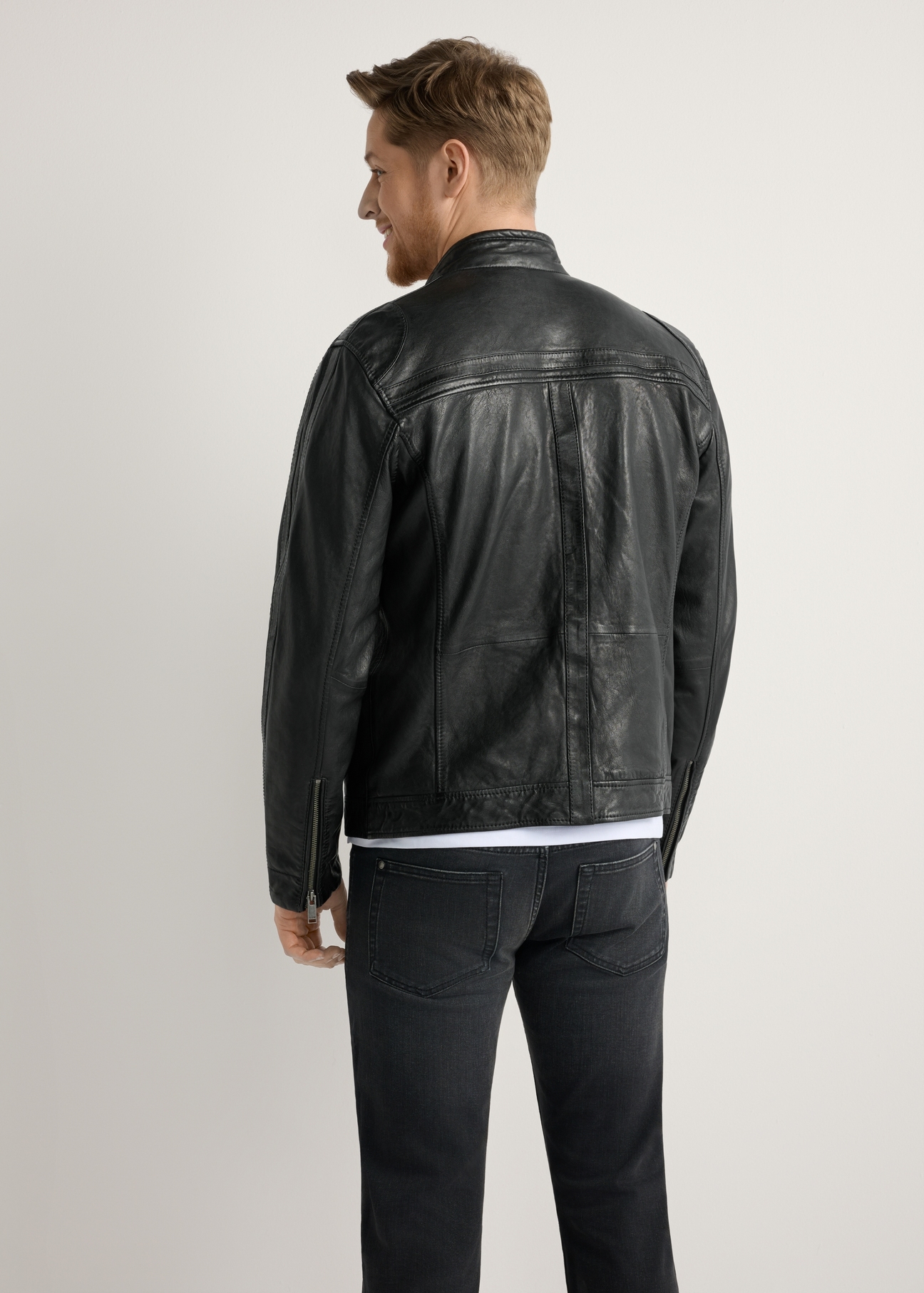 Men's black leather jacket KURMS-0397-99(W26) - back view of the product, on a model, against a light background. Knee-length silhouette visible.