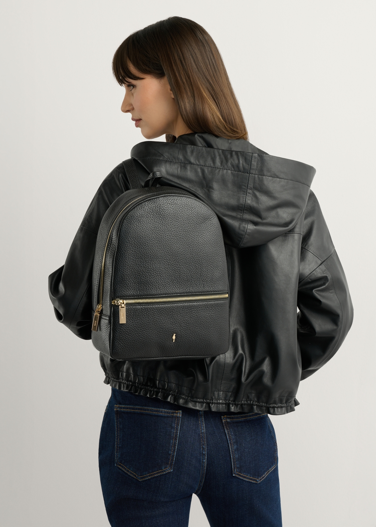 TORES-0898D-99(Z25) women's black leather backpack, front view of the product on a model. Half of the silhouette visible.