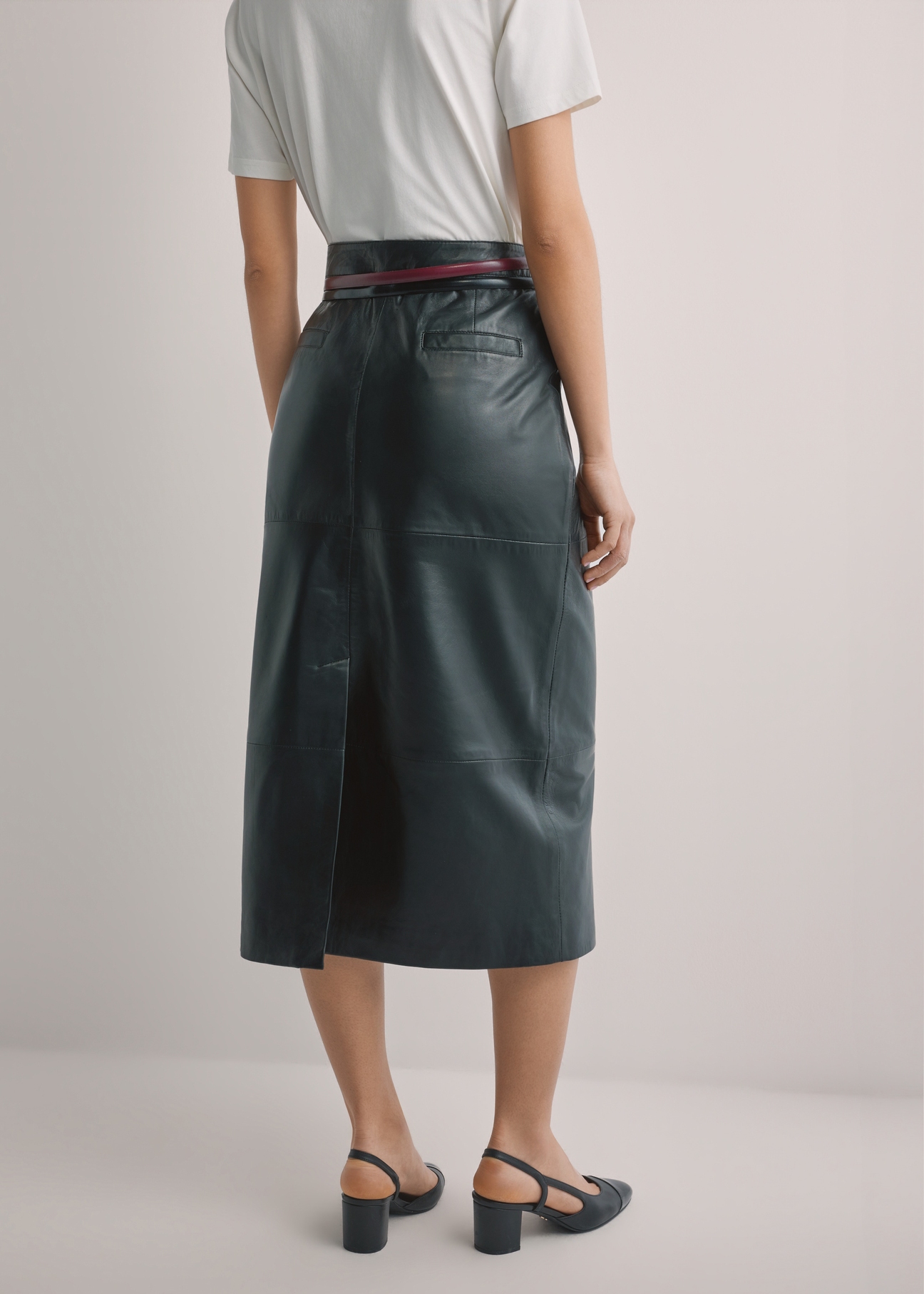 Black leather midi skirt SPCDS-0076-99(W26), back view of the product on the model. Half of the silhouette visible.