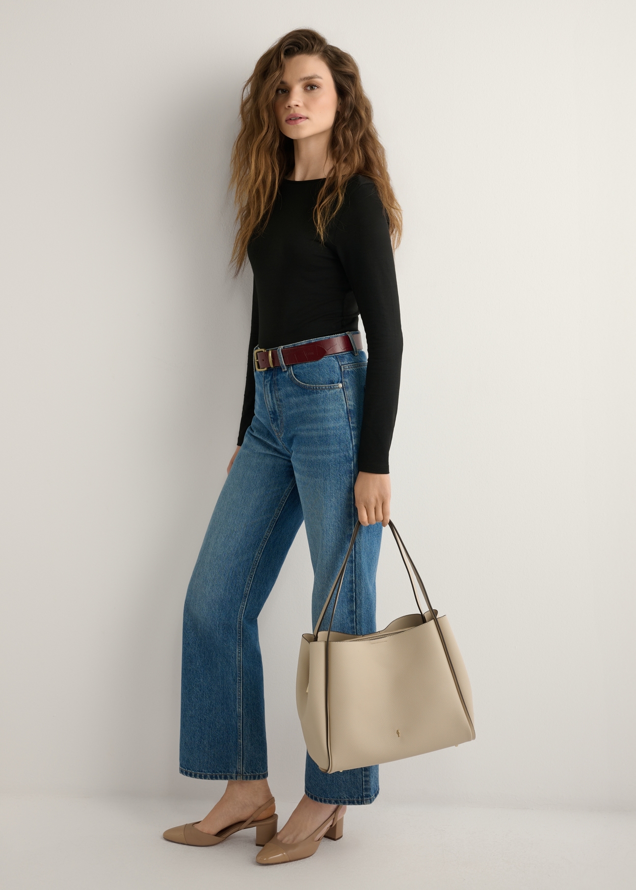 Beige women's shopper bag TOREC-1183-1A(W26) - front view of the product, held by the model, against a light background. The entire silhouette is visible.