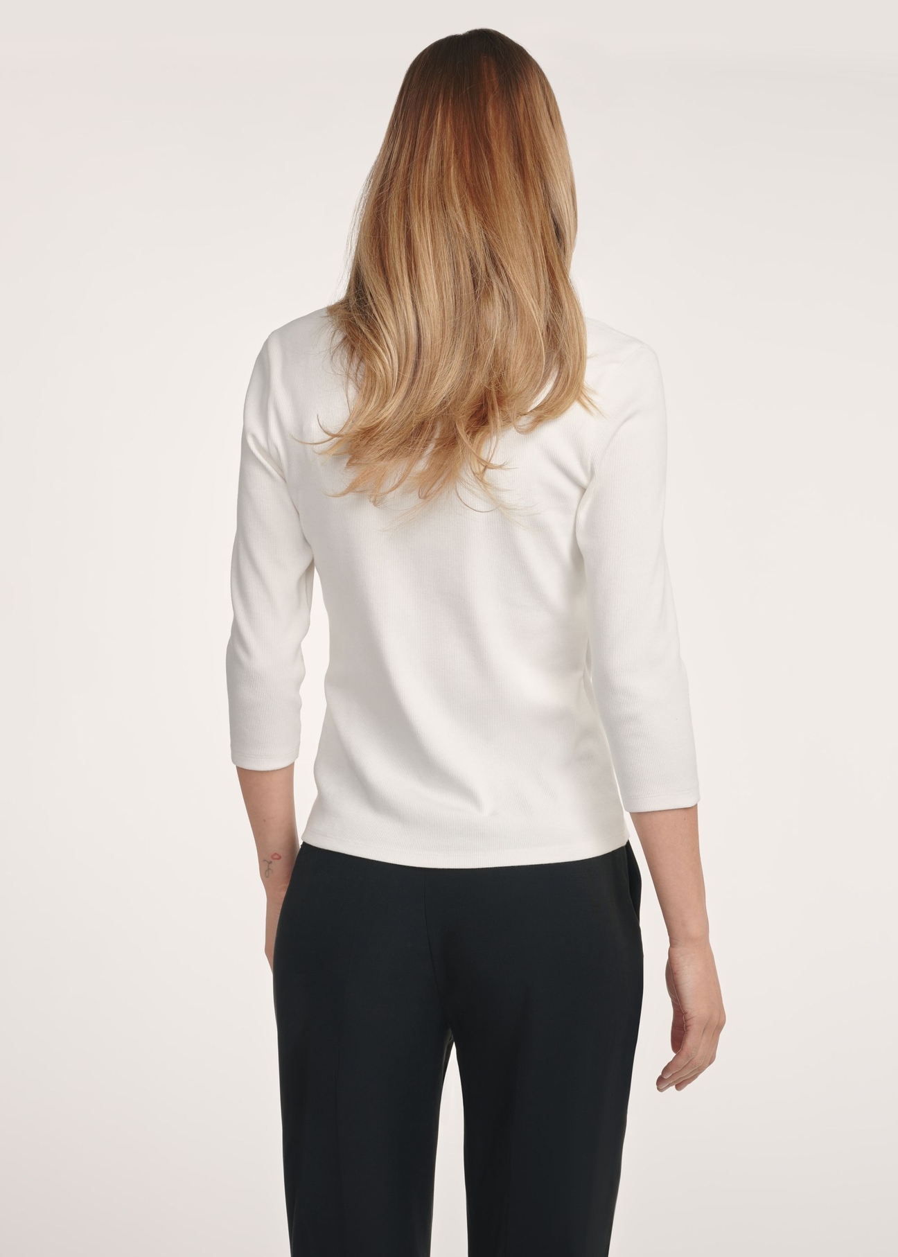 Cream women's blouse with a V-neck LSLDT-0036-0B(W26) - product view from the back, on a model, on a light background, half of the silhouette visible.