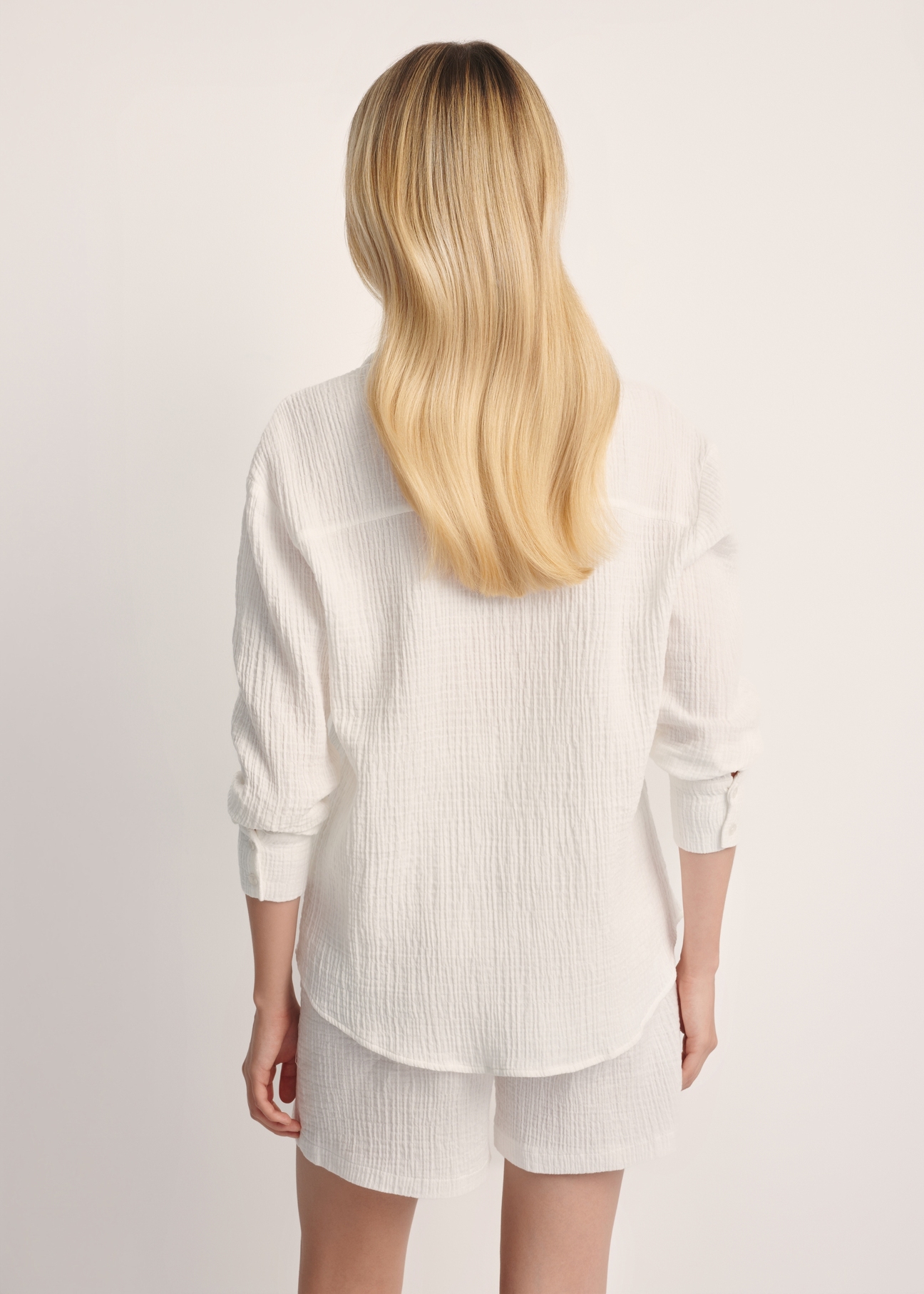 White women's long sleeve shirt KOSDT-0177-11(W25), product view from the back on the model. Half of the silhouette visible.