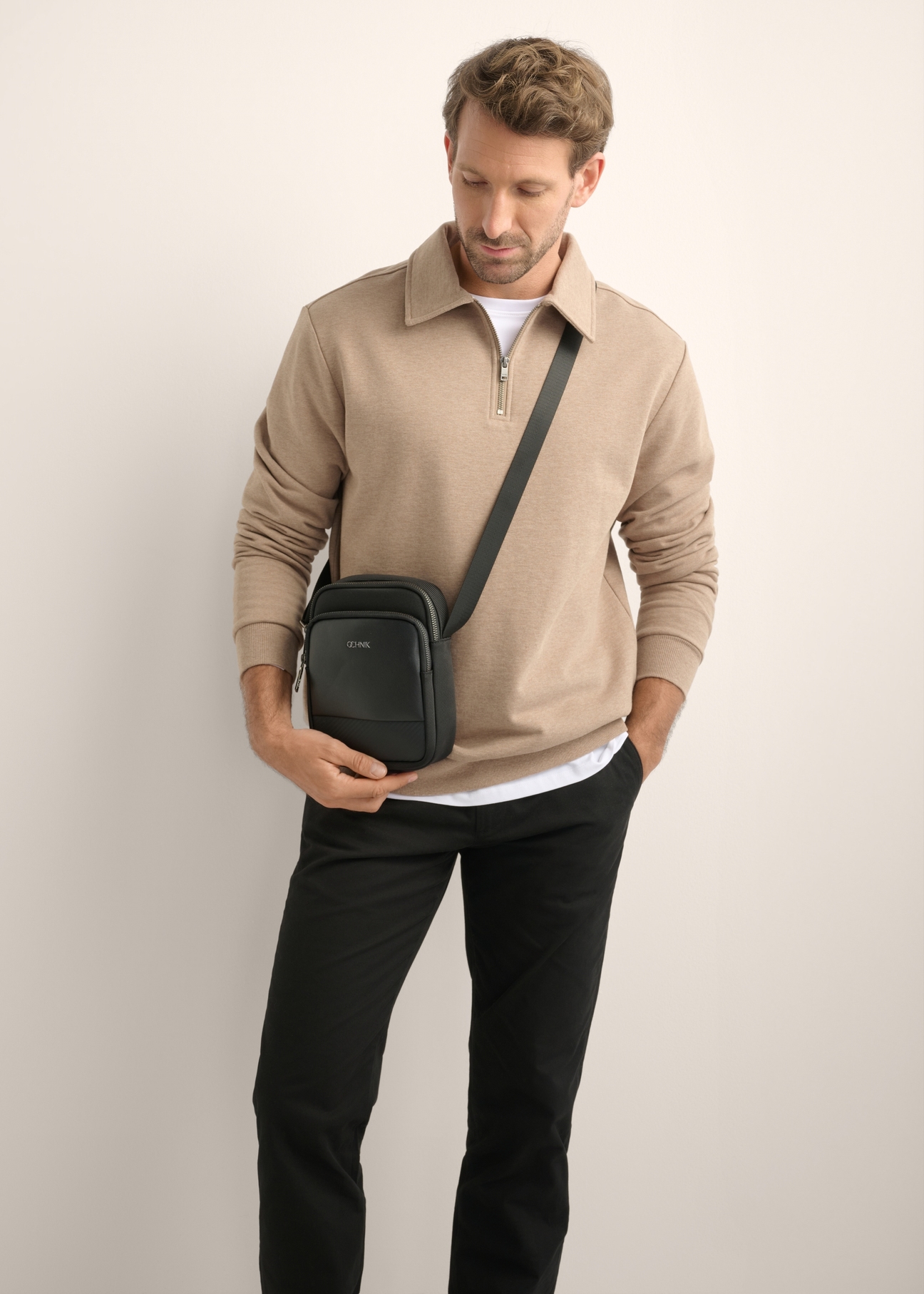 Men's black shoulder bag TORMN-0444-99(Z26), diagonal view of the product on the model. Half of the silhouette visible.