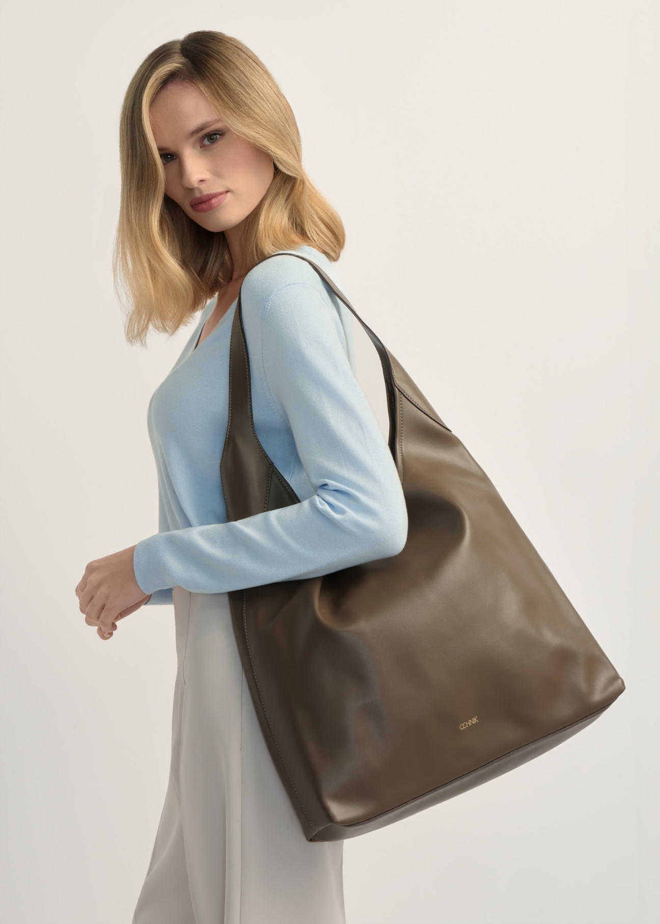 Light brown large women's handbag TOREC-1199-1K(W26), product view on model's shoulder. Half of silhouette visible.