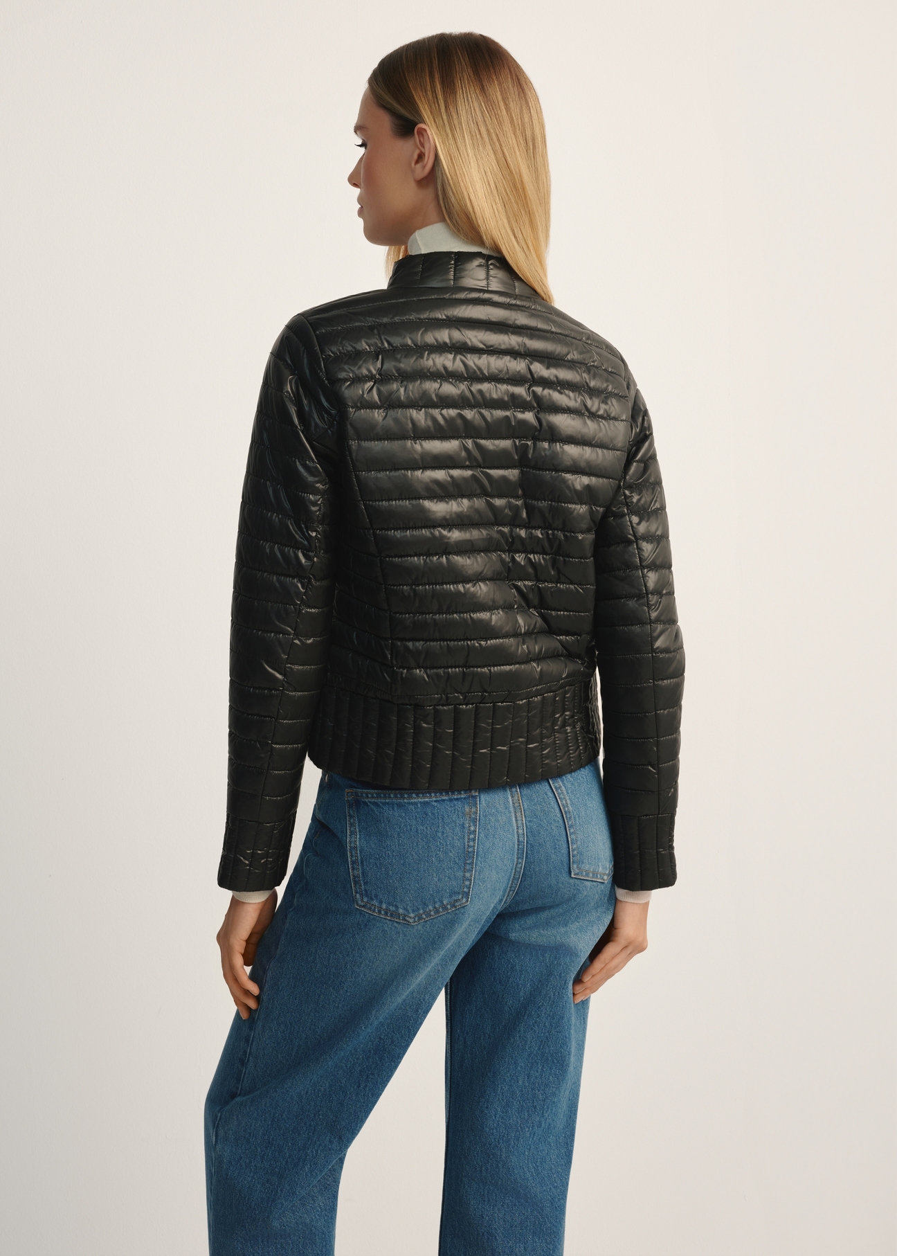 Black women's quilted jacket with a stand-up collar KURDT-0441-99(Z25), product view from the back on the model, half of the silhouette visible.
