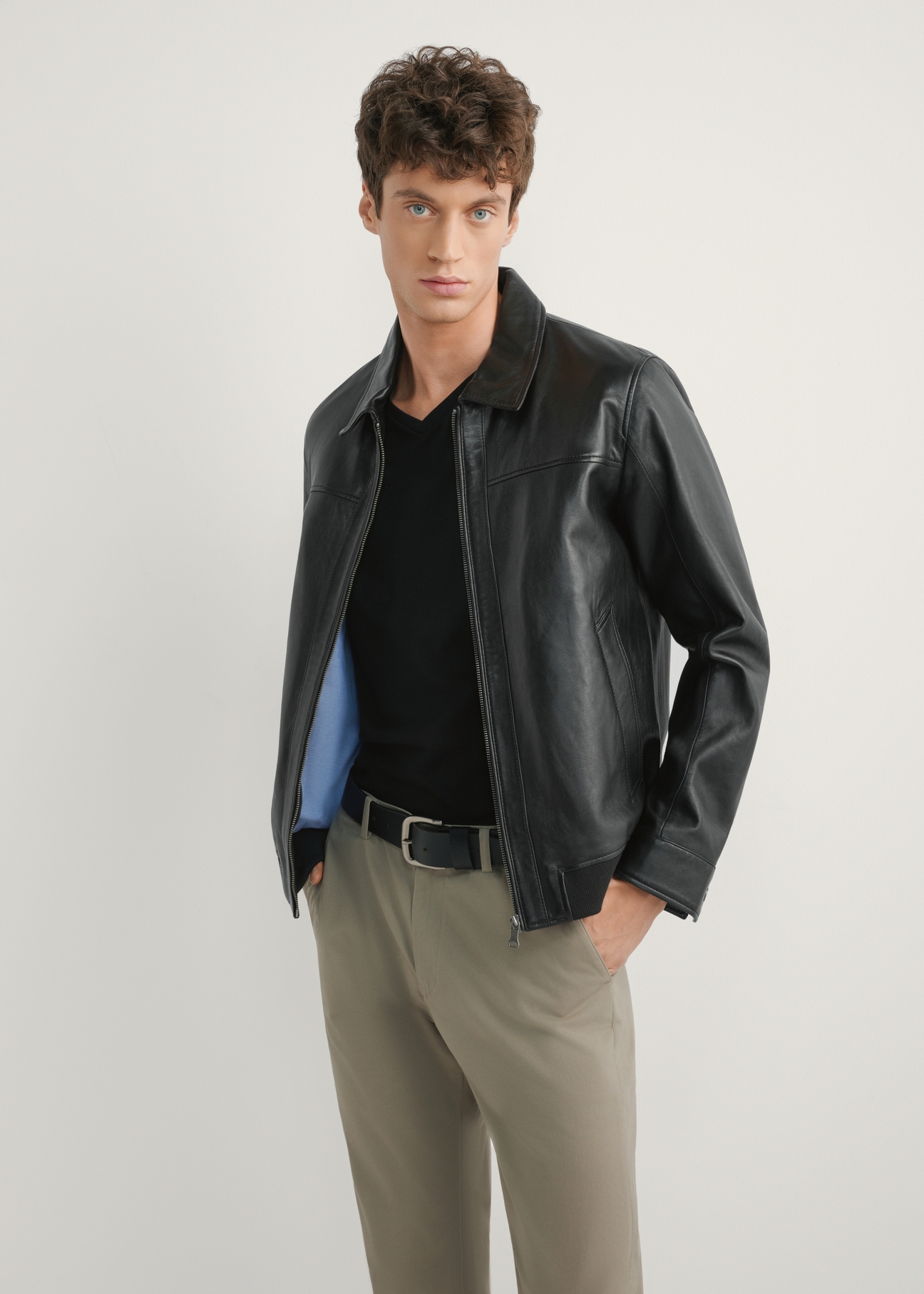 Black men's leather jacket KURMS-0407-99(W26), front product view on model. Half silhouette visible.