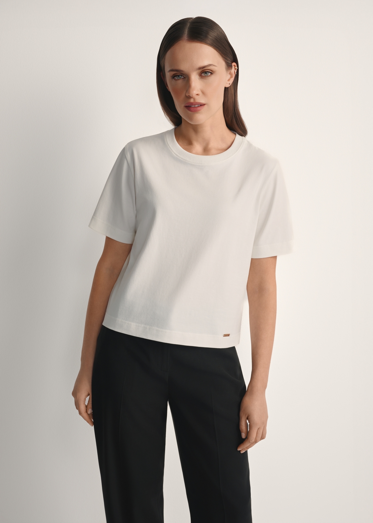 Women's cream cotton T-shirt TSHDT-0138-0B(W26), front view of the product on the model, half of the silhouette visible.