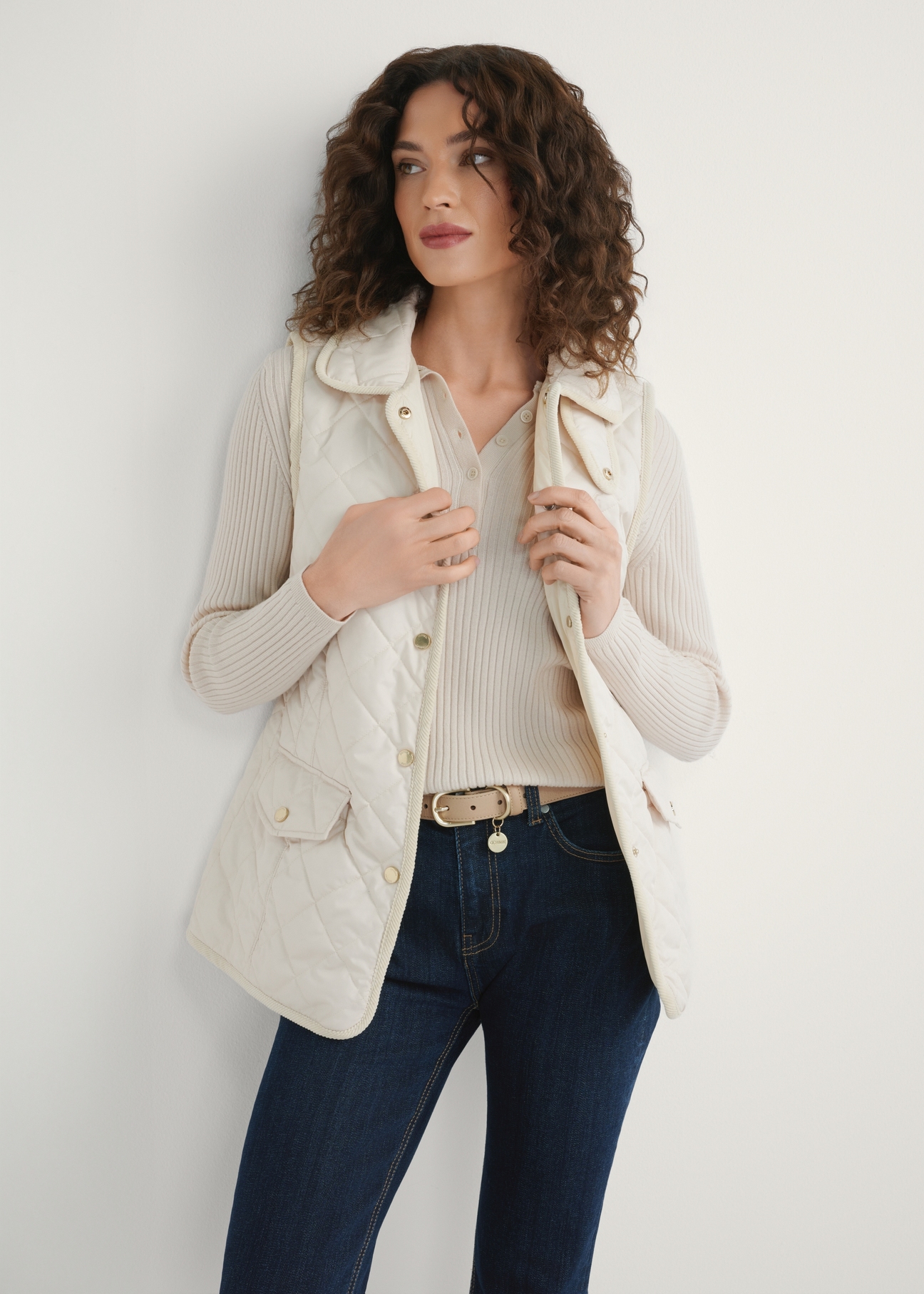 Light beige women's quilted vest KAMDT-0036-0B(W26) - front view of the product, on a model, against a light background. Half of the silhouette visible.