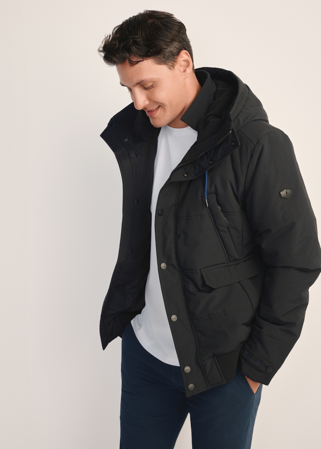 Black men's winter jacket KURMT-0273-99(Z25) - side view of the product on the model, on a white background.