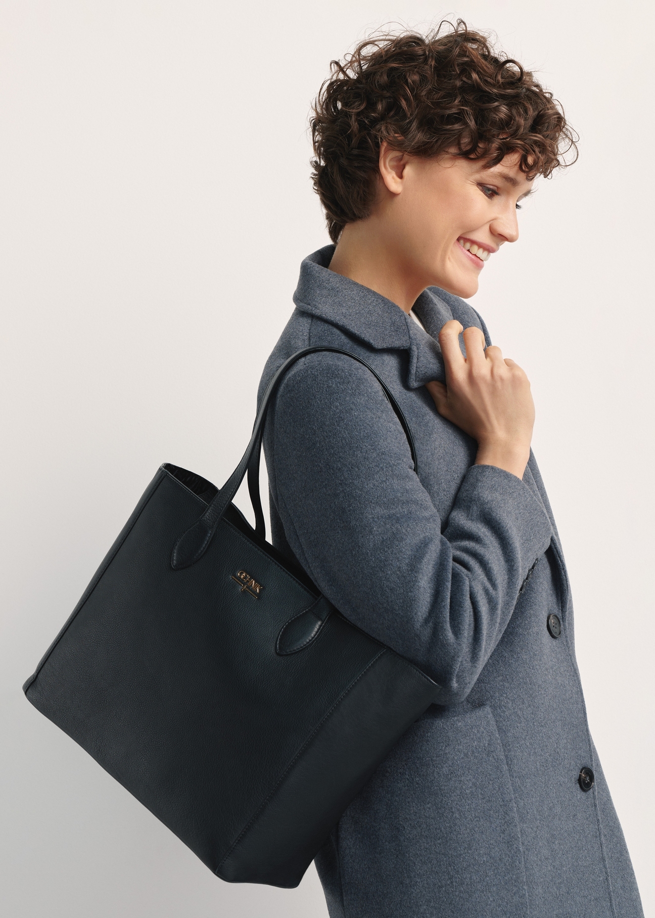 Black leather women's shopper bag TORES-0971F-99(W26), front view of the product on a model, half of the silhouette visible.