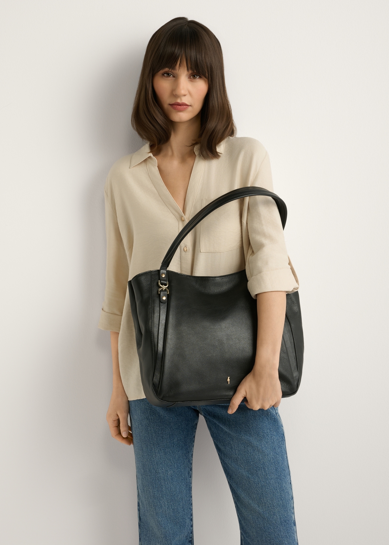 Black leather shopper bag TORES-1223-99(W26), product view in model's hand. Half of silhouette visible.