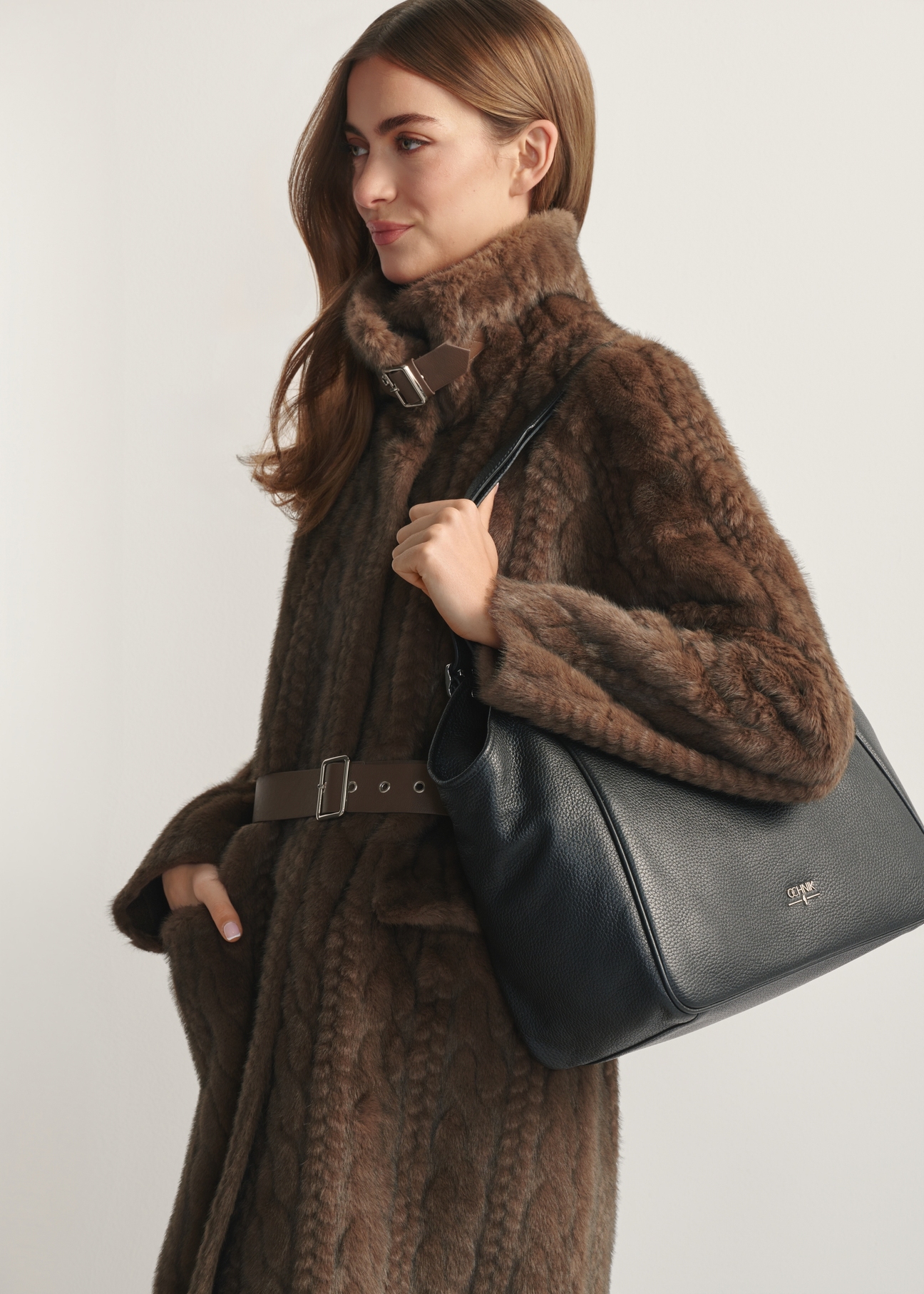 Large black leather women's handbag TORES-1042D-99(Z25) - side view of the product, on a model, against a light background. Half of the silhouette visible.