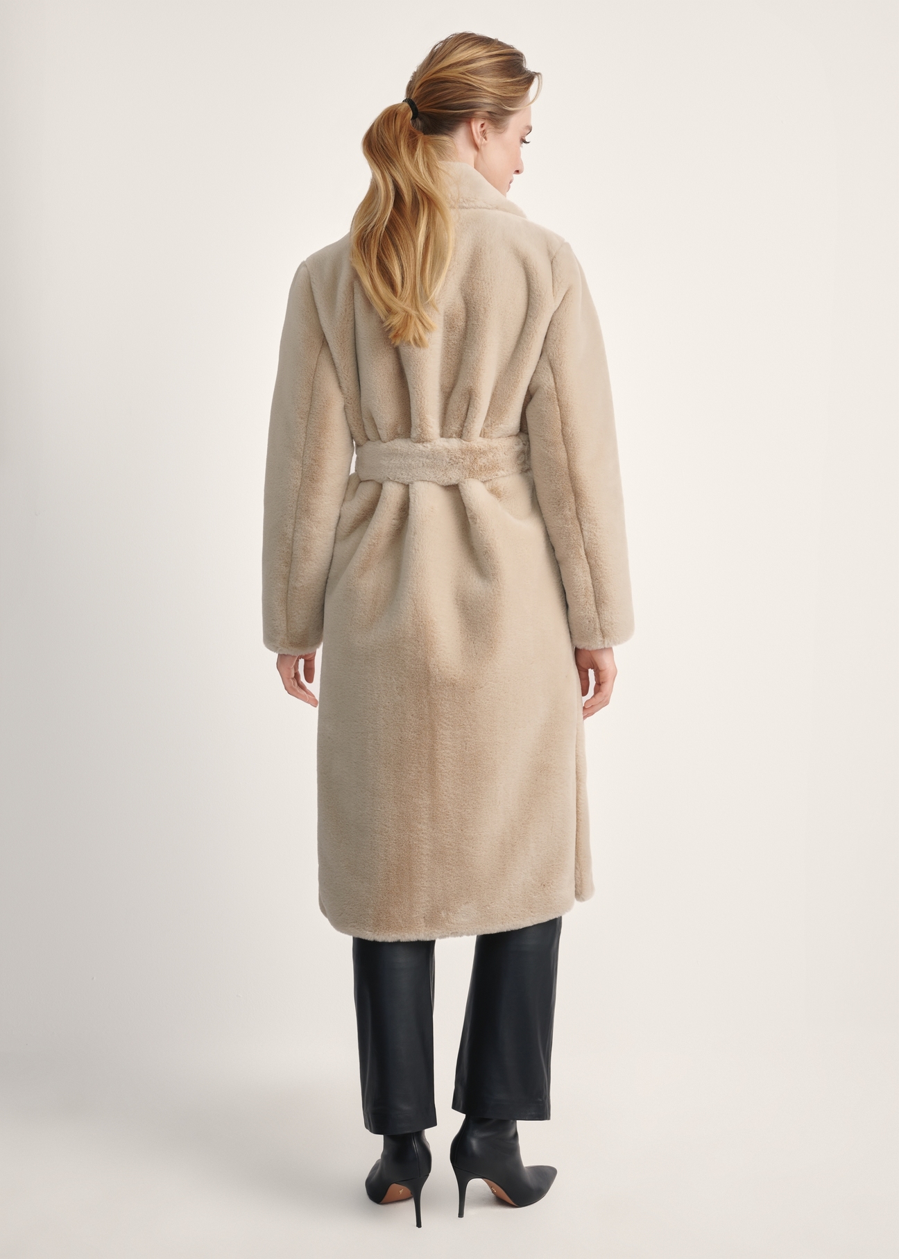 Women's faux fur coat with belt FUTDP-0002A-81(Z24), product visible from the back on the model, the entire silhouette is visible.