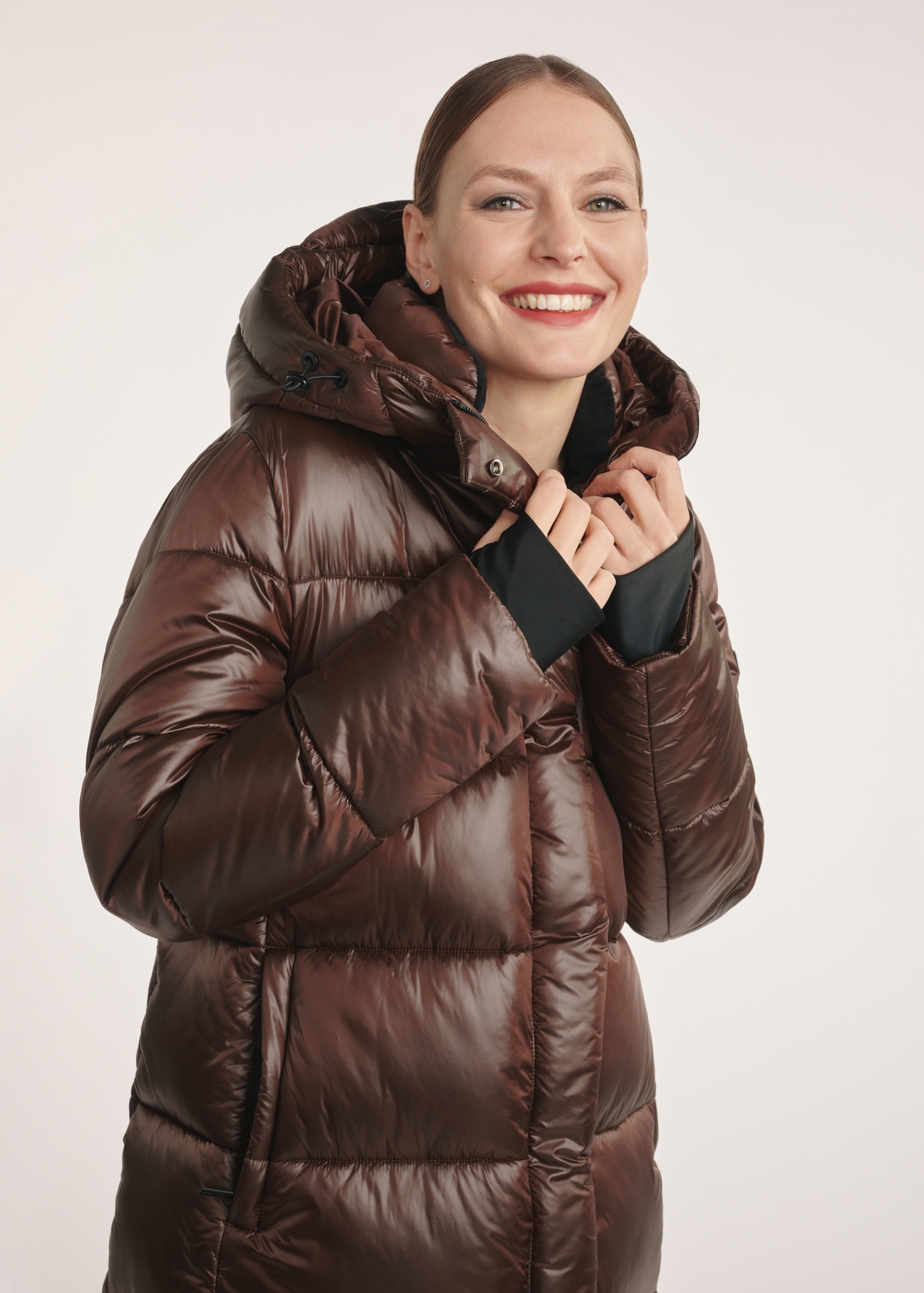Brown long winter women's jacket KURDT-0531-89(Z25) - front view on a model on a white background. Half of the silhouette visible.