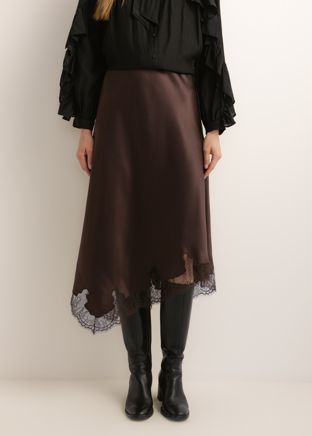 Dark brown asymmetrical women's skirt SPCDT-0135-1I(Z26), front view of the product on the model. Half of the silhouette visible.