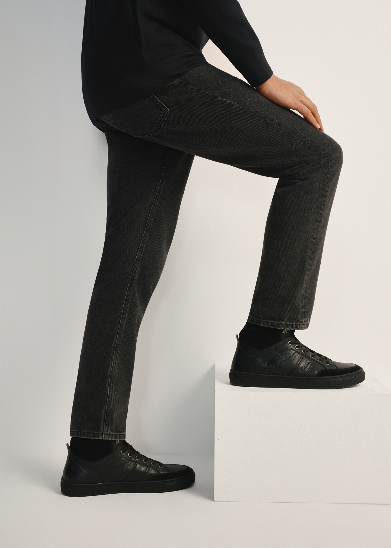 Black leather men's sports shoes BUTYM-0476-99(Z25), side view of the product on the model, half of the silhouette visible.