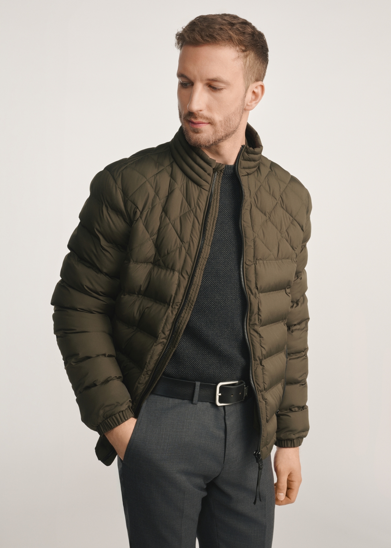 Olive quilted men's jacket KURMT-0401-57(Z25) - front view of the product on a model on a white background. Half of the silhouette visible.
