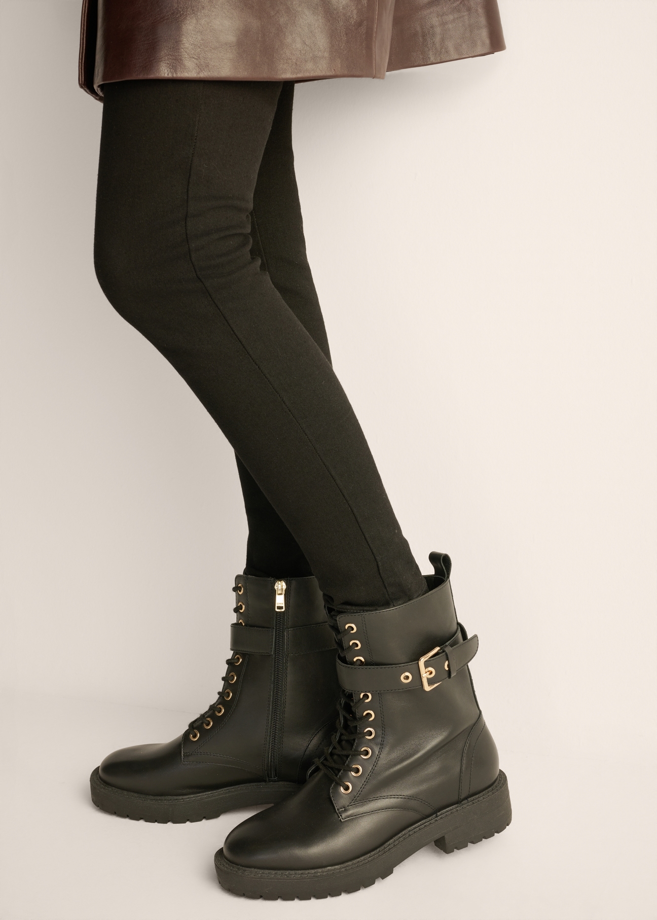 Women's black leather ankle boots BUTYD-1311-99(Z26), side view of the product on the model. Half of the silhouette visible.