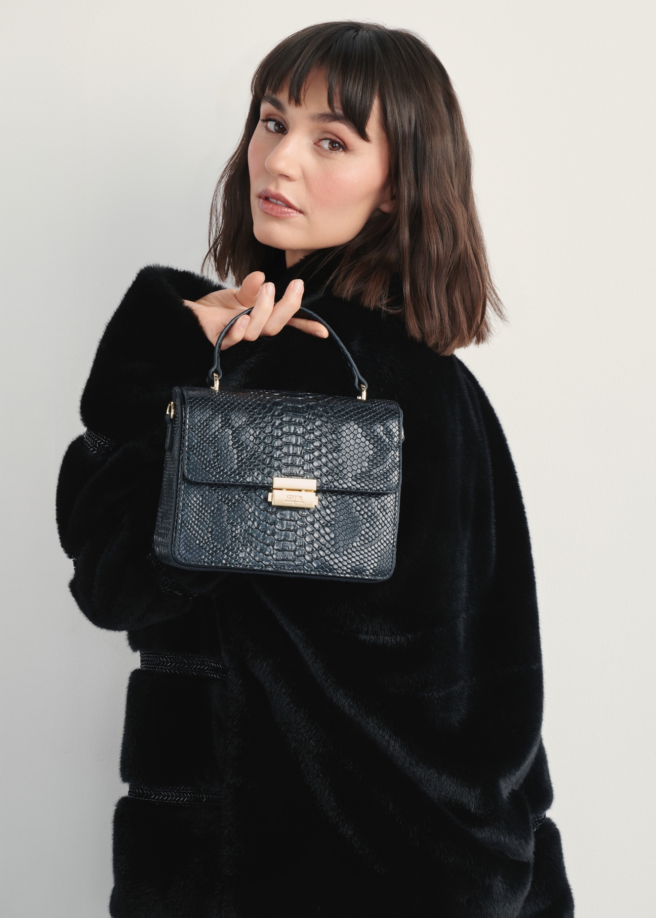 Black women's handbag TOREC-1080-98(Z25) - front view of the product on a model, against a white background. Half of the back of the silhouette is visible.