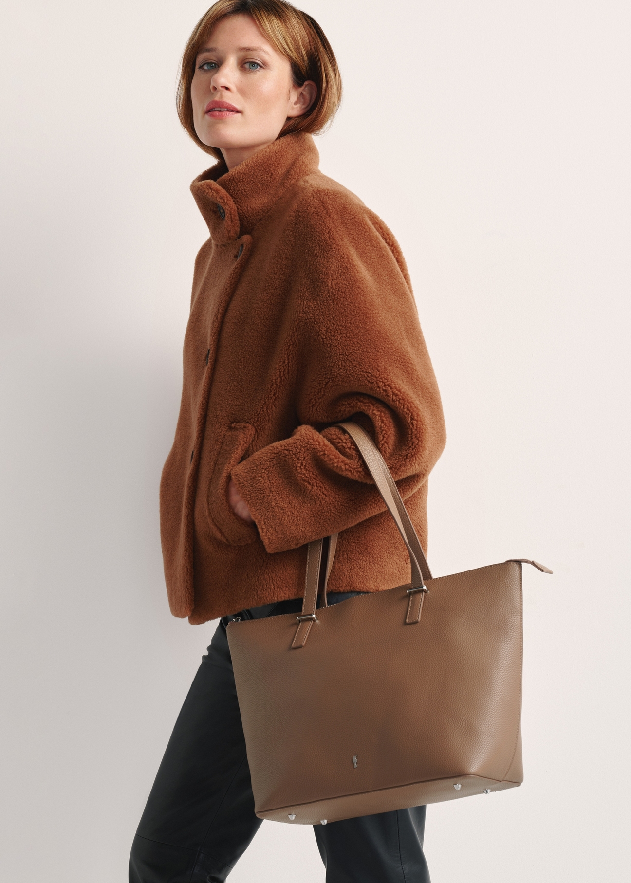 Beige large women's shopper bag TOREC-0953A-81(Z25), product view from the front on the model, half of the silhouette visible.