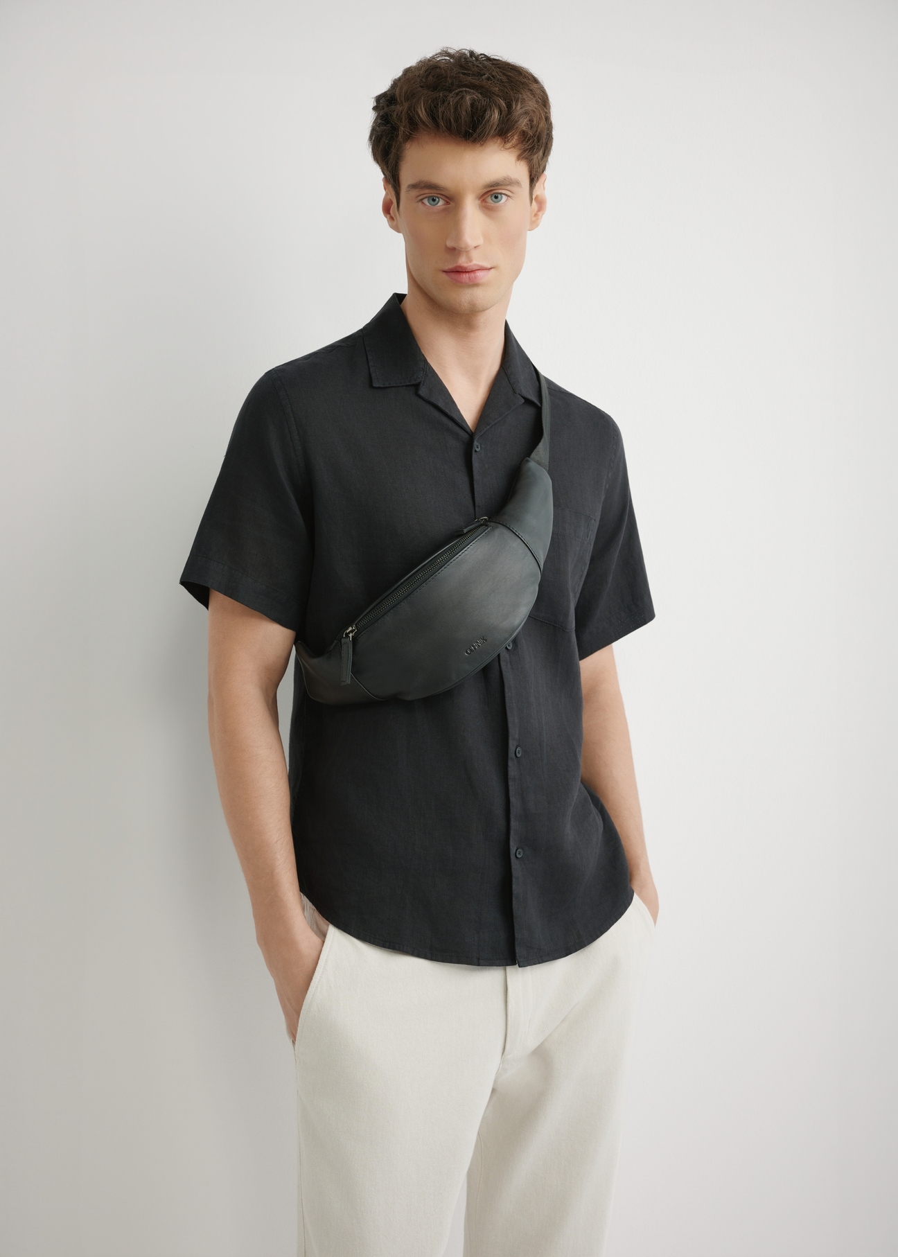 Men's black leather waist bag TORMS-0497-99(W26), front product view on the model's silhouette.