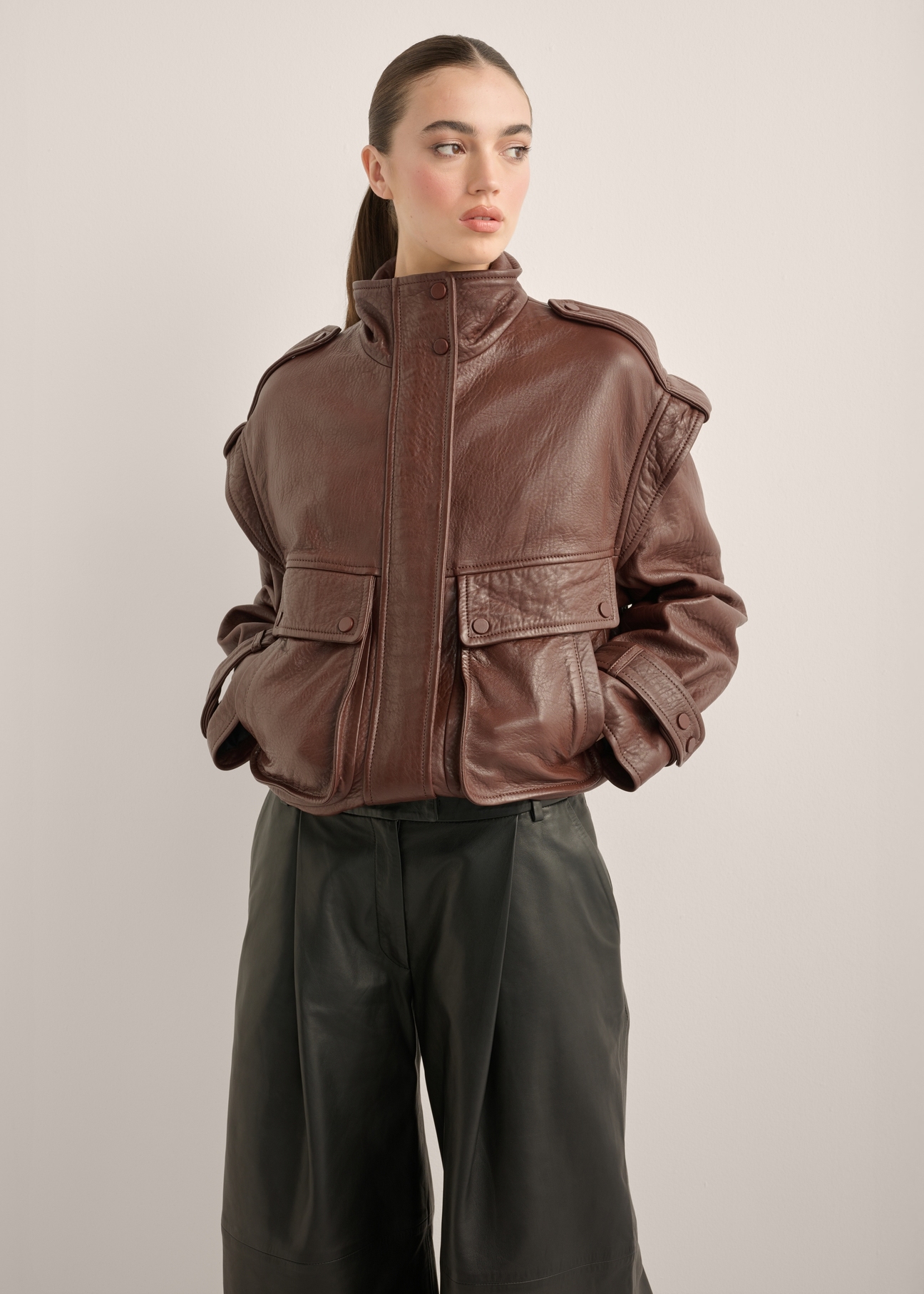 Women's burgundy oversize leather jacket KURDS-0644-4D(Z26), front view of the product on the model. Half of the silhouette visible.