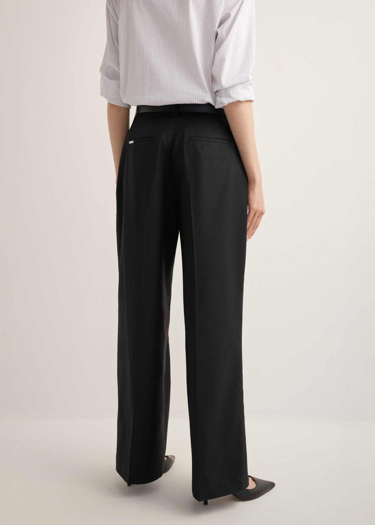Women's black wide-leg trousers with a crease SPODT-0126-99(Z26), back view of the product on the model. Half of the silhouette visible.