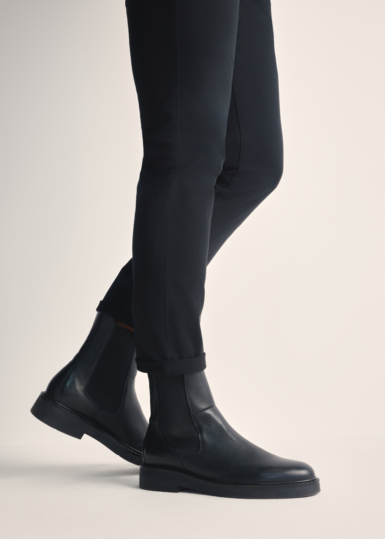 Black leather men's Chelsea boots BUTYM-0462-99(Z25), product view on model's feet against a light background.