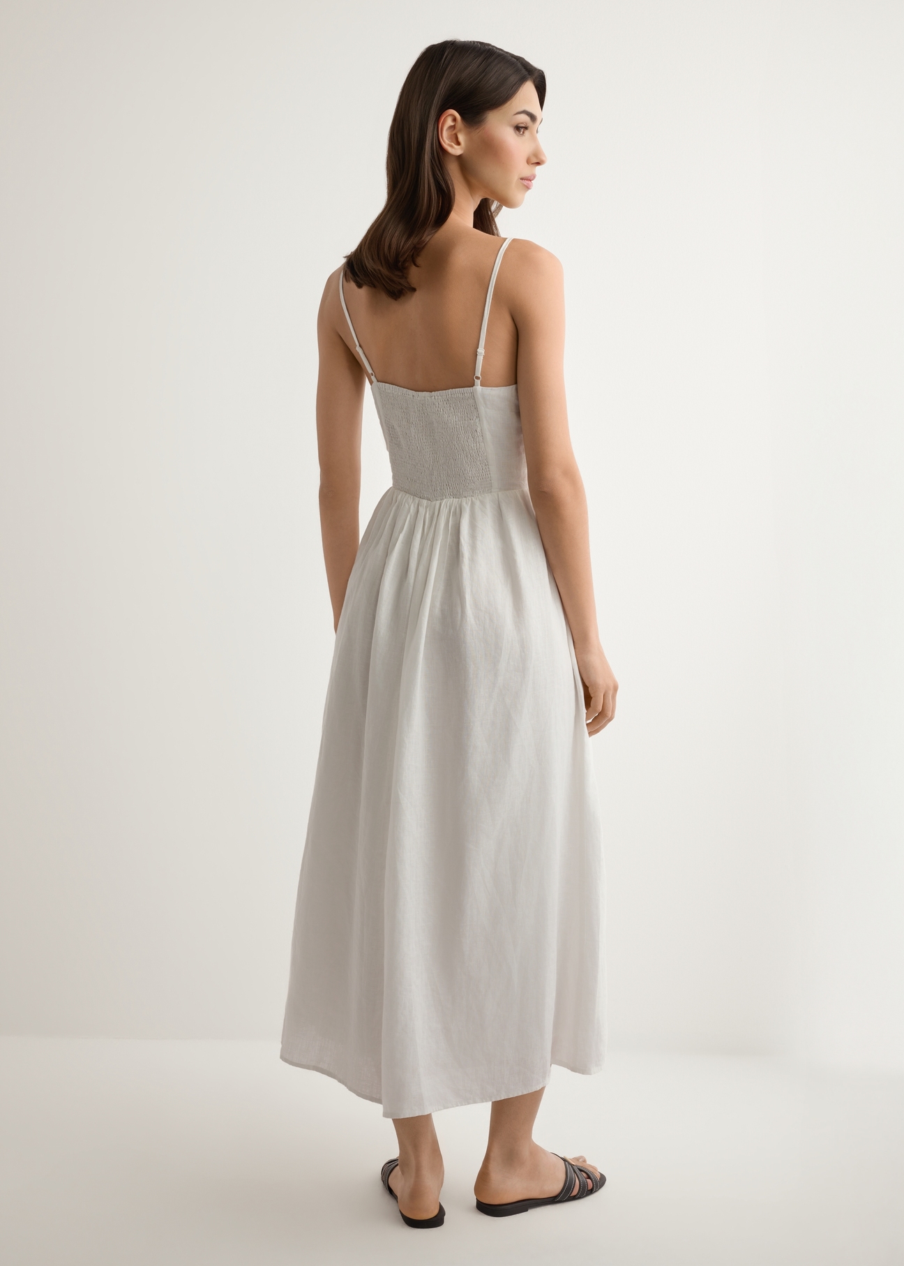 White linen midi dress with straps SUKDT-0279-0B(W26), back view of the product on the model. Full body visible.