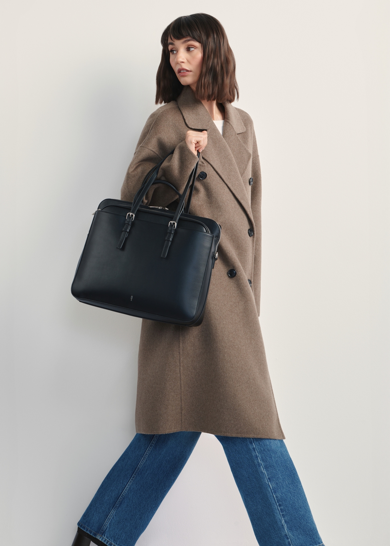 Black women's laptop bag TOREC-1108-99(Z25), front view of the product on a model, the entire silhouette is visible.