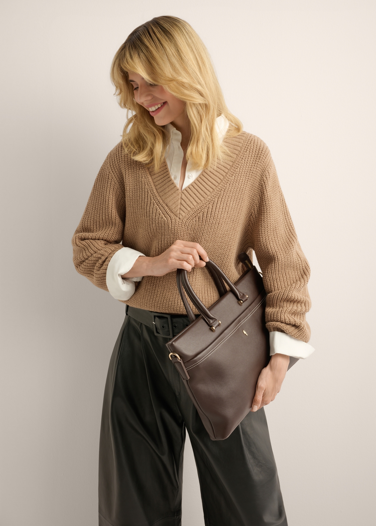 Brown women's briefcase TOREC-1372-1H(Z26), product view in model's hand. Half of silhouette visible.