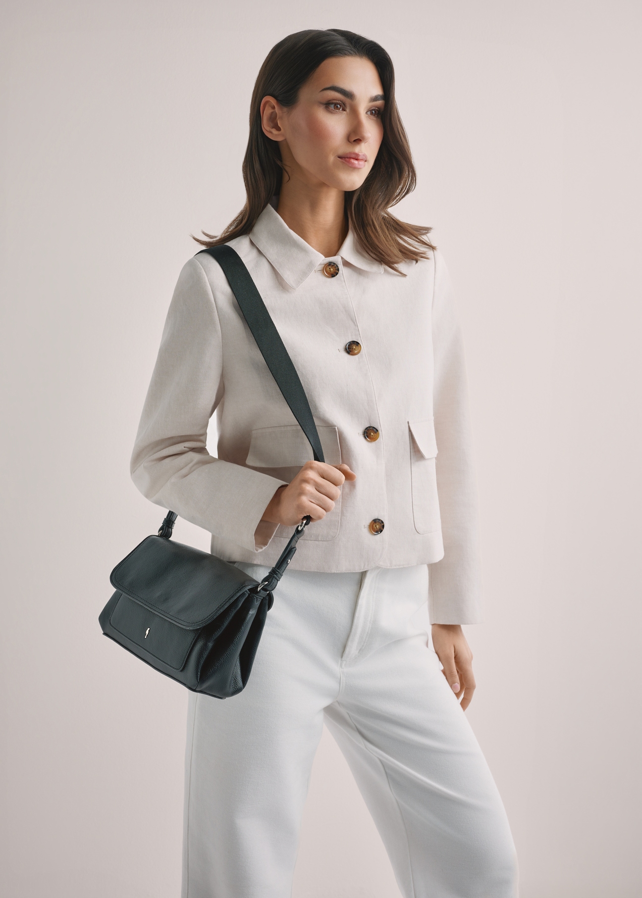 Black classic women's handbag TOREC-1124-99(W26), front view of the product on the model's shoulder. Half of the silhouette visible.