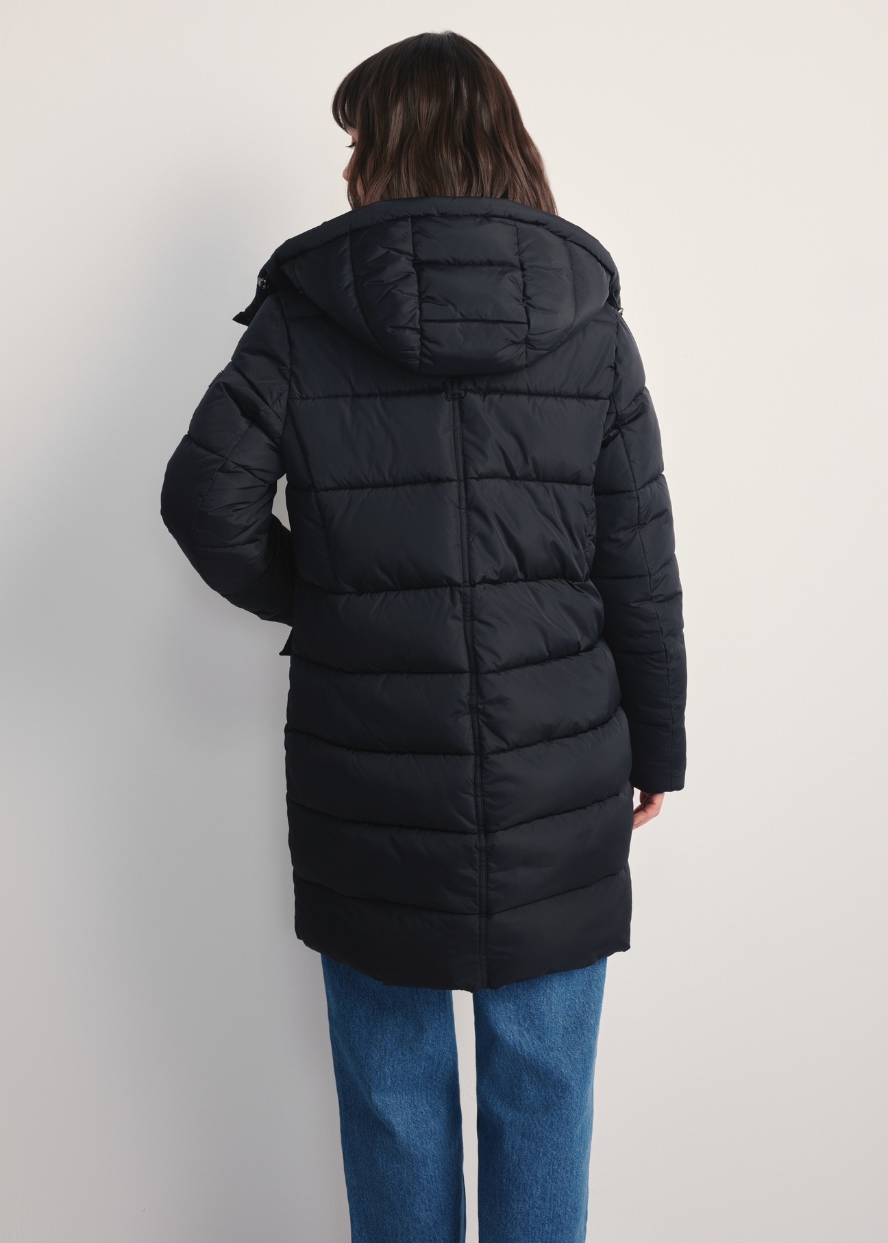 Women's black winter jacket KURDT-0600-99(Z25) - back view of the product on a model against a white background. Knee-length silhouette visible.