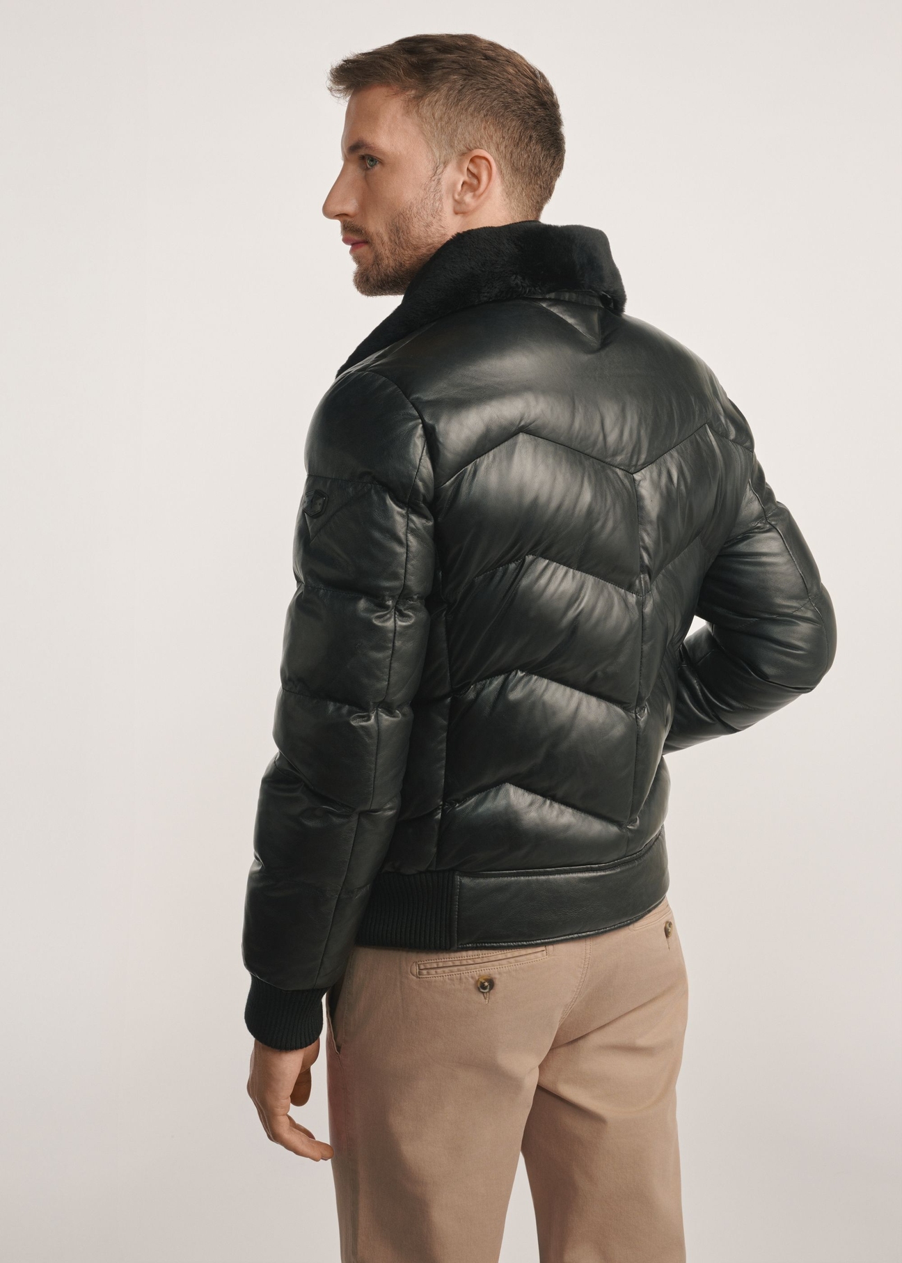 Black men's leather jacket with insulation KURMS-0377-1127(Z25), product view from the back on the model, half of the silhouette visible.
