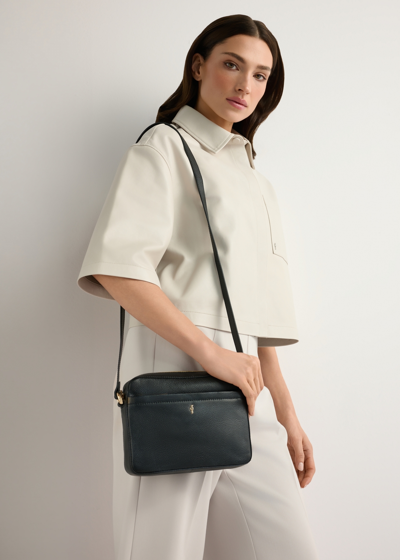Small black leather women's handbag TORES-1269-9I(W26), product view on model's shoulder. Half of silhouette visible.