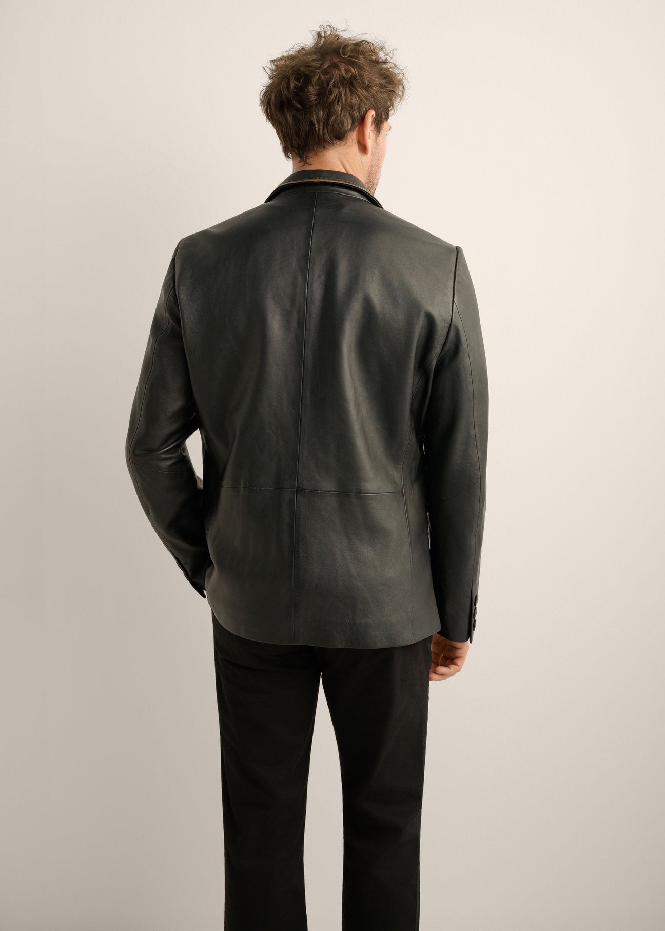 Black vintage men's leather jacket KURMS-0402-9J(Z26). Rear view of the product on a model. Half of the silhouette is visible. 