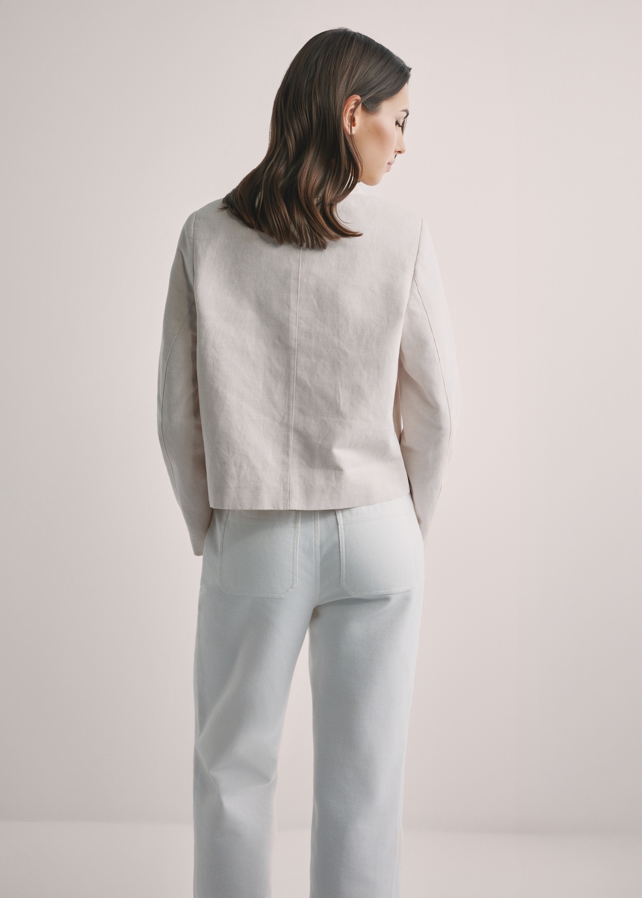Light beige women's linen jacket KURDT-0652-1A(W26), back view of the product on the model. Half of the silhouette visible.