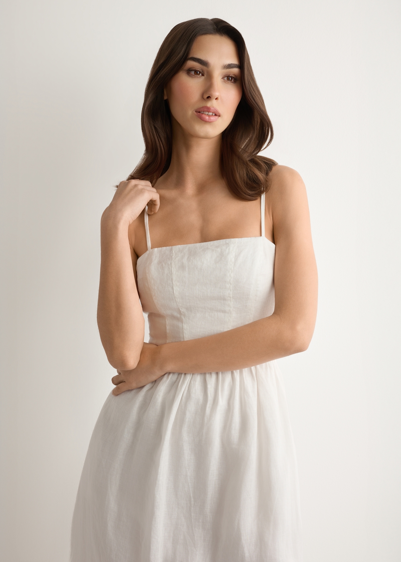 White linen midi dress with straps SUKDT-0279-0B(W26), front view of the product on the model. Half of the silhouette visible.