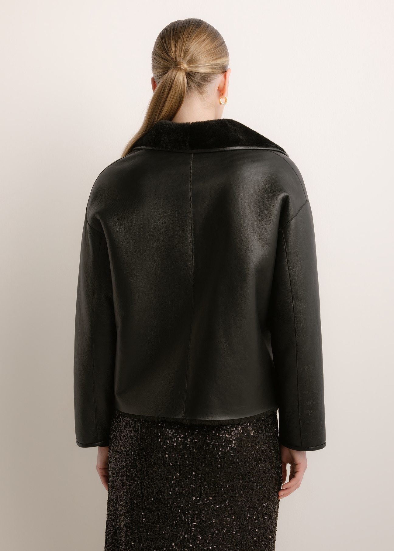 Women's black leather sheepskin coat KOZDS-0105-99(Z26), product view from the back on the model. Half of the silhouette visible.