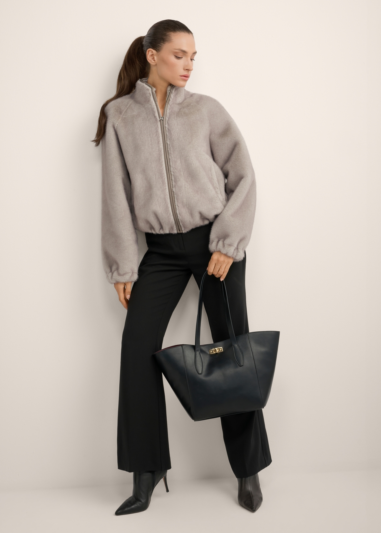 Black women's shopper bag TOREC-1375-99(Z26), product view in model's hand. Full body visible.