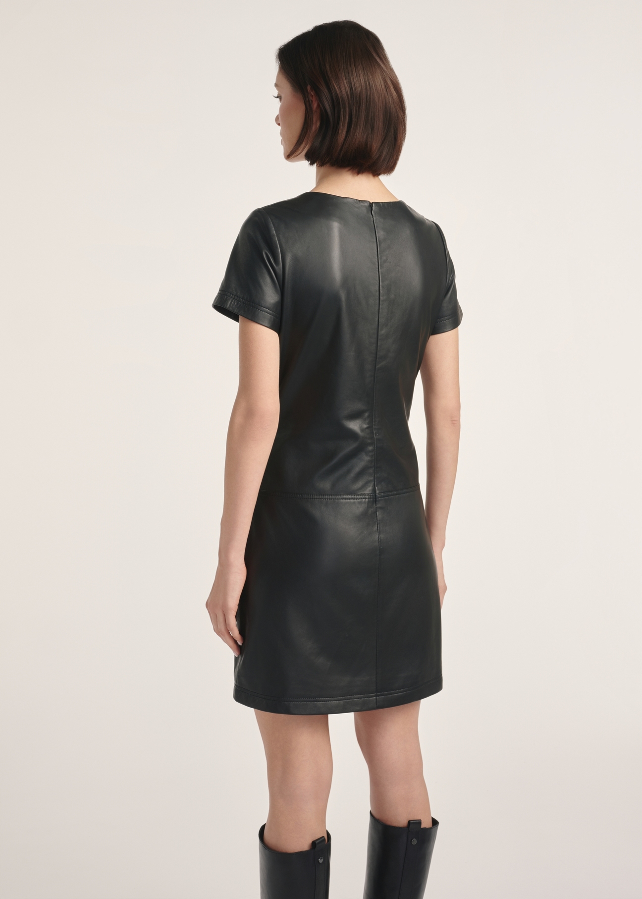 Black leather mini dress SUKDS-0052-1276(Z25), product visible from the back on the model, half of the silhouette visible.