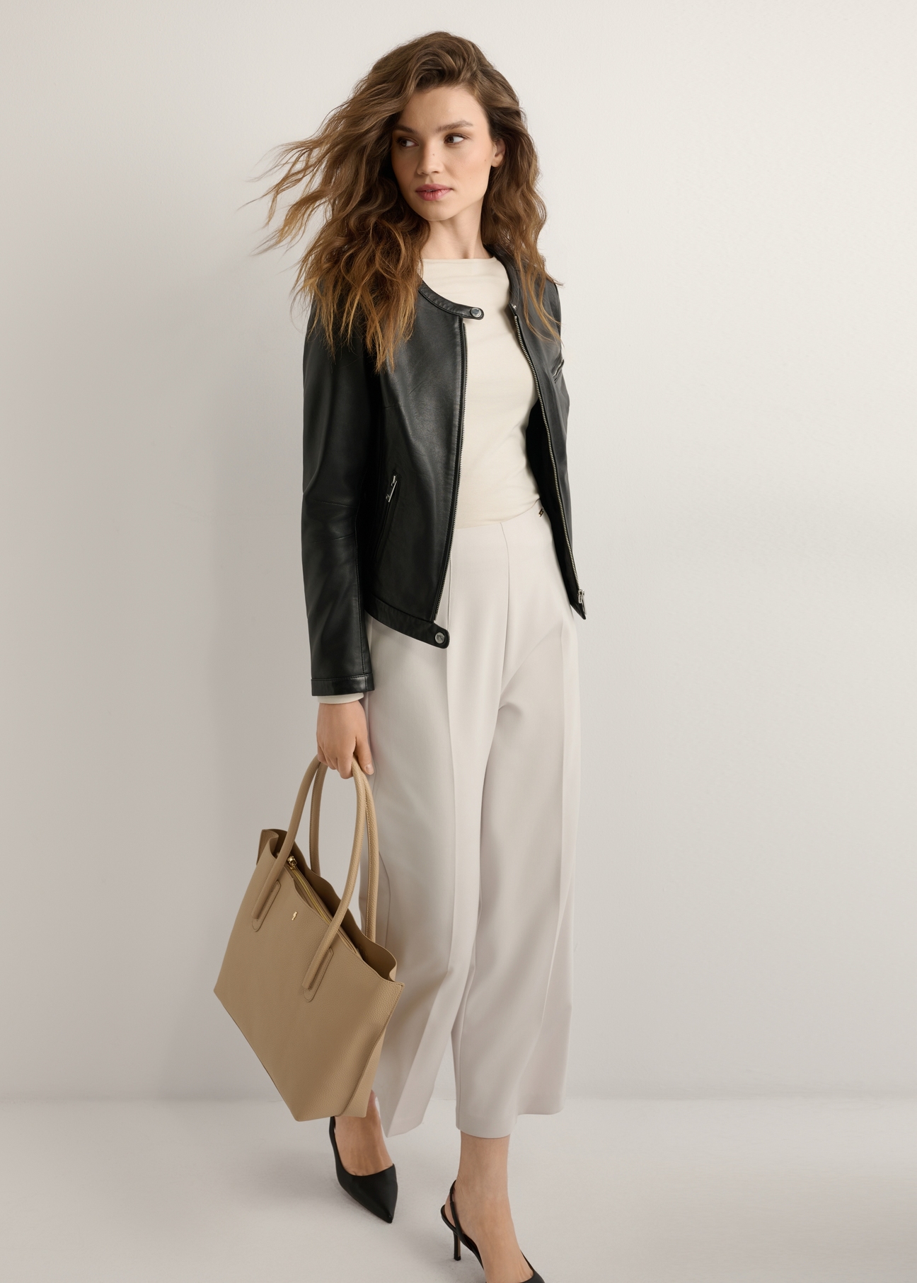 Dark beige women's shopper bag TOREC-0938-1C(W26), diagonal view of the product on the model, the entire silhouette is visible.