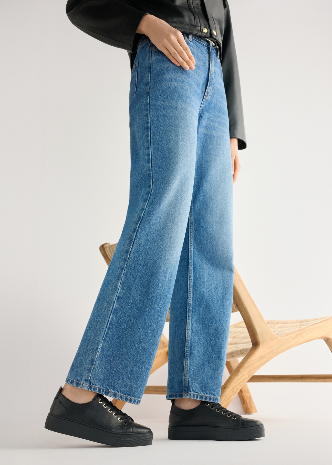 Women's high-top black leather sneakers BUTYD-1062-99(W26) - side view of the product, on a model, against a light background. Knee-length silhouette visible.