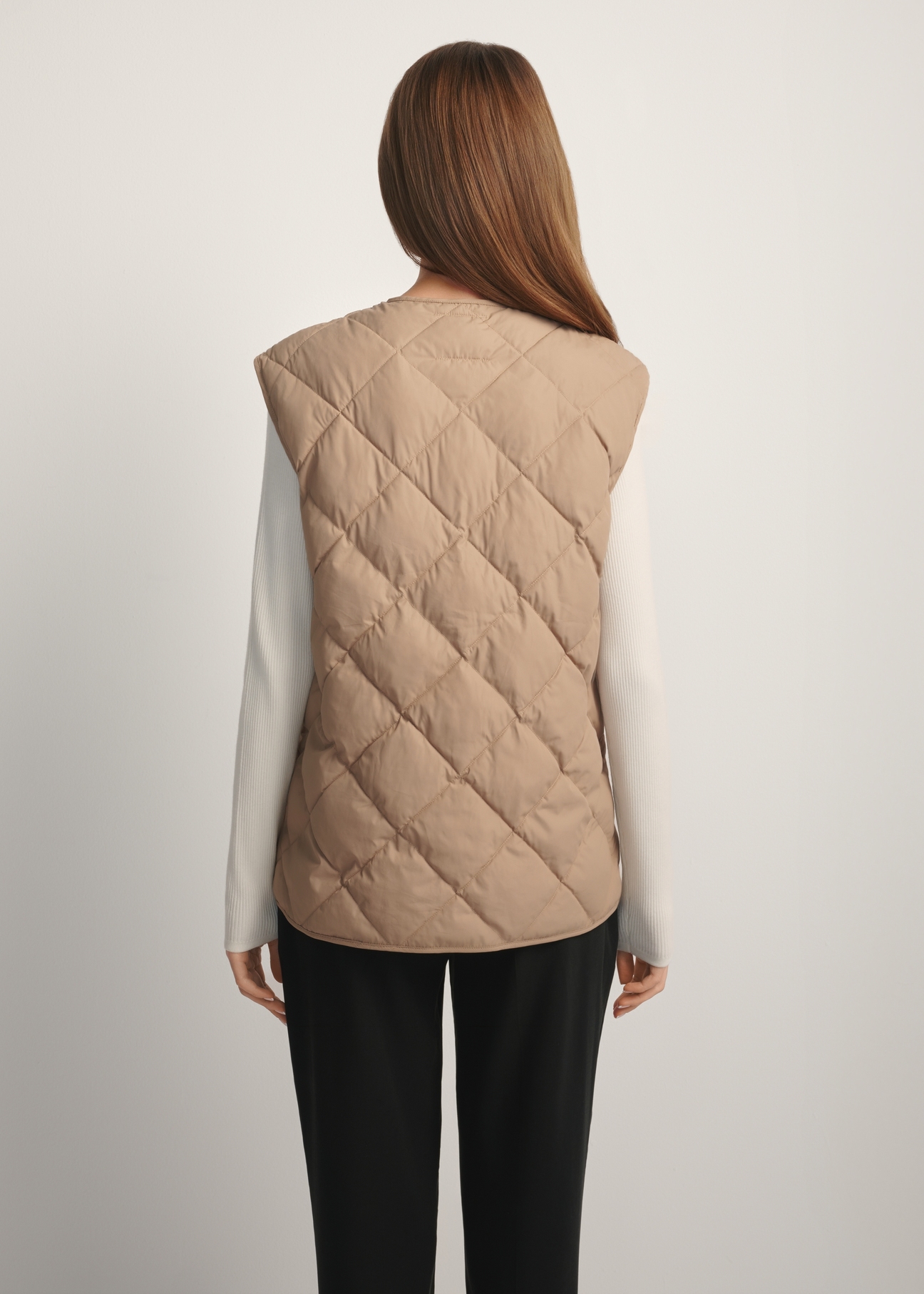 Beige women's quilted vest KAMDT-0035-1C(W26), back view of the product on the model. Half of the silhouette visible.