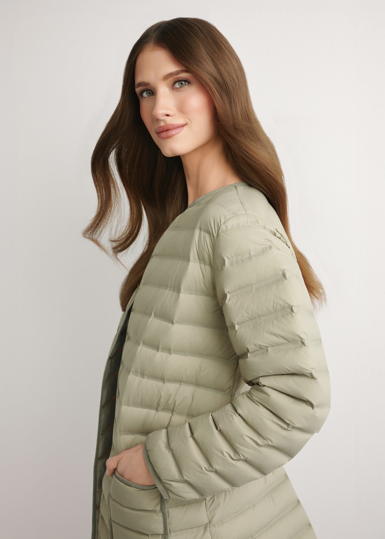 Women's olive green jacket with natural insulation KURDT-0636-8E(W26) - side view of the product, on a model, against a light background. Half-length silhouette visible.