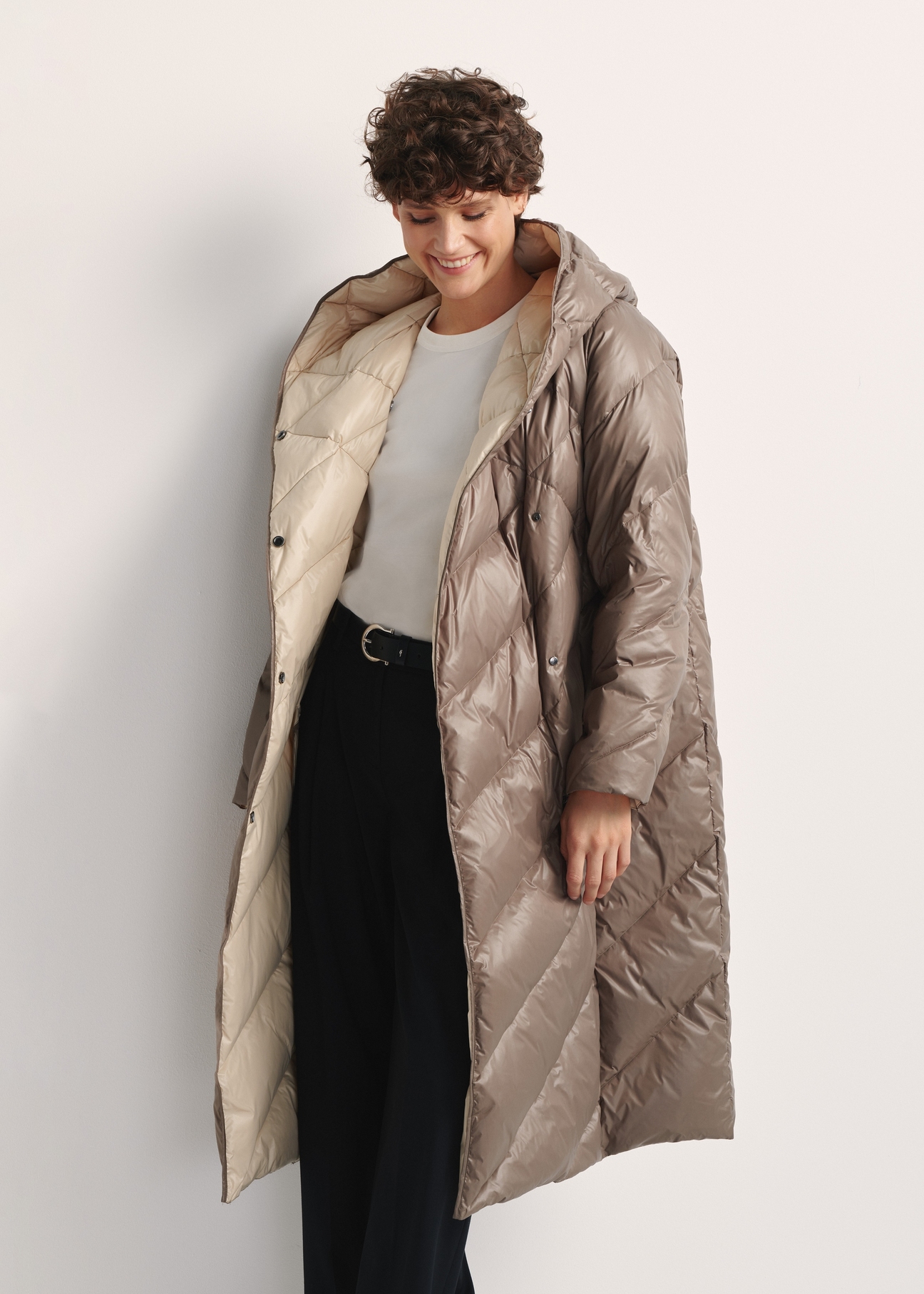 Long olive women's winter jacket KURDT-0542A-57(Z25), front view of the product on the model, part of the silhouette visible.
