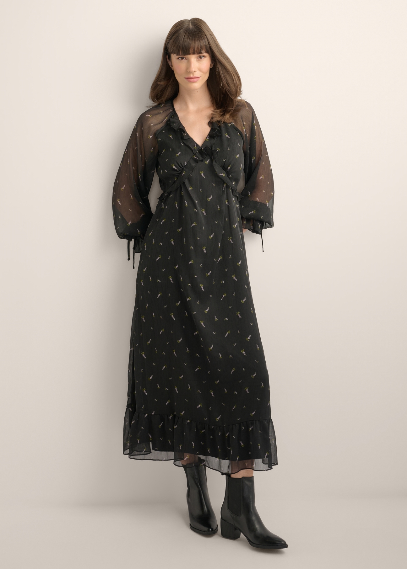 Black maxi dress with a lilac pattern and ruffles SUKDT-0290-9P(Z26), product view from the front on the model. Full body visible.